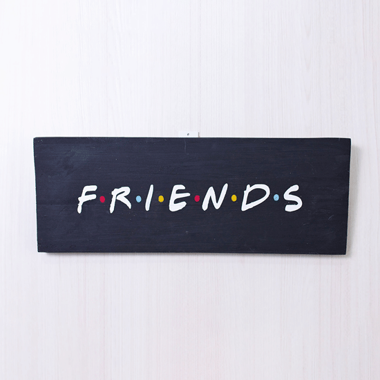 Pieza de madera con la palabra Friends pintada a mano 