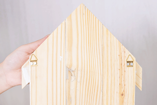 Pieza de madera en forma de casa con ganchos 